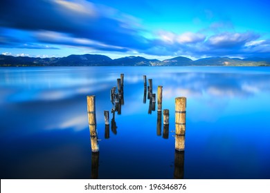 Wooden pier or jetty remains on blue lake sunset and sky reflection water. Long exposure, Versilia Massaciuccoli, Tuscany, Italy. - Powered by Shutterstock