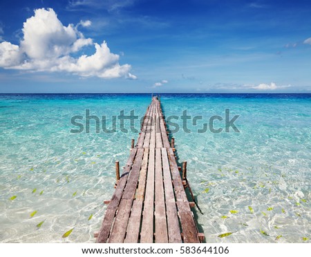 Wooden pier on a tropical island, clear sea and blue sky