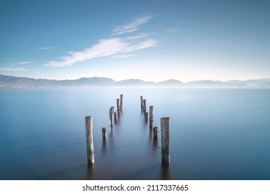 Wooden pier remains and lake at sunrise. Long Exposure. Massaciuccoli lake. Torre del Lago Puccini, Versilia, Tuscany, Italy, Europe - Powered by Shutterstock