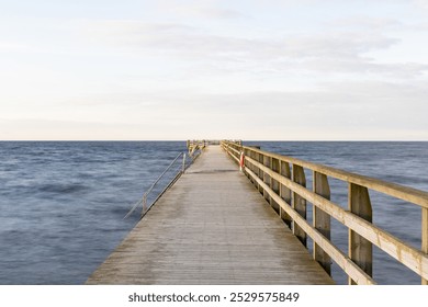 Wooden pier stretching out towards empty horizon - Powered by Shutterstock