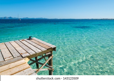 Wooden pier turquoise sea water sunny day, Alcudia beach, Majorca island - Powered by Shutterstock