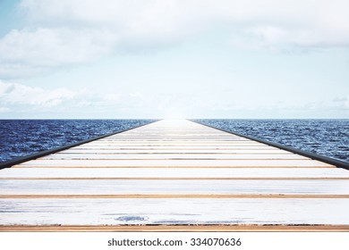 Wooden Pier In The Water With Light Sky 