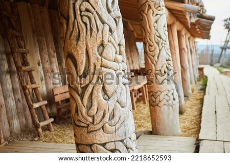 Wooden pillars with carvings in the ethnic village museum. Scenery for films about Vikings.