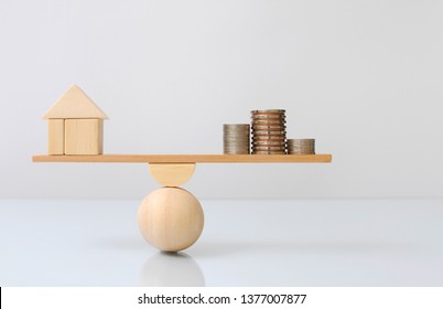 Wooden Plank Balancing Of Wood Home And Coins Money Comparison Of Income Control Expense. Property Investment And House Mortgage. Financial Realestate Business Concept