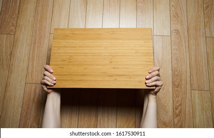 wooden plank for inscription in hand. Hands holding big blank paper over head - Powered by Shutterstock