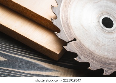 Wooden planks and circular saw blade on the carpenter workbench close up background. - Shutterstock ID 2225919847