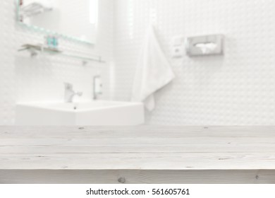 Wooden planks surface and blurred bathroom interior as background.