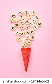 Wooden plaques with numbers and signs in an ice cream cone on a colored background. Study material in mathematics, the Montessori method. Problem solving concept. Laser cutting and printing on wood.