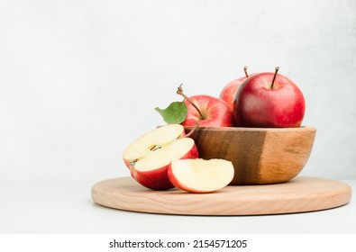 wooden plate with fresh red apples on a light background - Shutterstock ID 2154571205