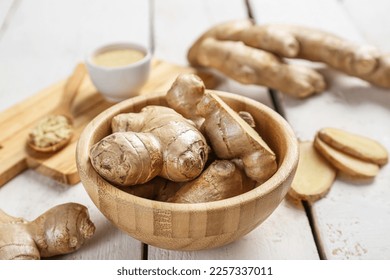 Wooden plate with ginger roots on light wooden background - Powered by Shutterstock