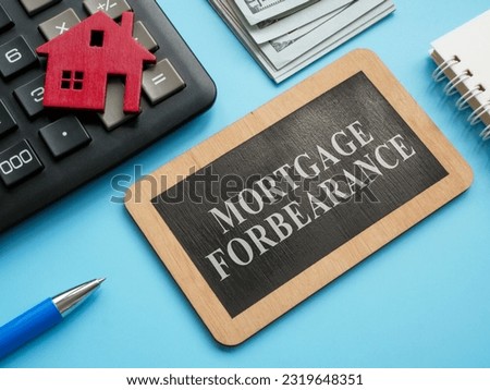 Wooden plate with inscription mortgage forbearance and model of house.