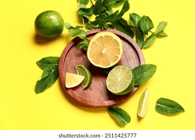 Wooden plate with lime, lemon and fresh mint leaves on yellow background - Powered by Shutterstock