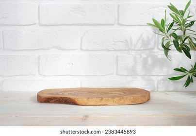 Wooden podium on table with green plant leaves and white brick wall background - Powered by Shutterstock