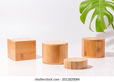 Wooden podiums for product display and monstera leaves on white background