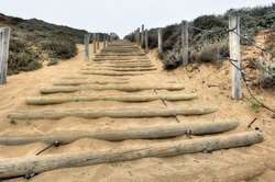 Wooden Poles With Cable Ties Form Stairs Up A Steep Sand Hill