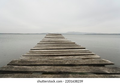 A Wooden Pontoon On A Dream Beach. South Ural, Russia. Pontoon Jetty Across The Water. Empty Summer Lake. Wooden Ponton On Water For Boat Fishing. No People. 