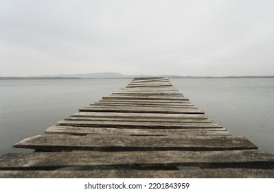 A Wooden Pontoon On A Dream Beach. South Ural, Russia. Pontoon Jetty Across The Water. Empty Summer Lake. Wooden Ponton On Water For Boat Fishing. No People. 