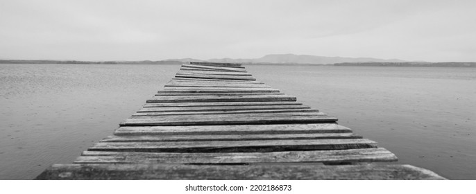 A Wooden Pontoon On A Dream Beach. South Ural, Russia. Pontoon Jetty Across The Water. Empty Summer Lake. Wooden Ponton On Water For Boat Fishing. No People. 