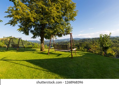 Wooden Porch Swing In Garden With View Of Vineyard In Austria, Summer In Europe