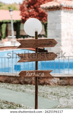A wooden post with decorative arrows, one of which reads 