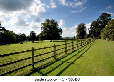 Wooden post and rail fencing around a tidy empty paddock - Shutterstock ID 1477560458