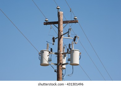 Wooden power utility pole and clear blue sky.