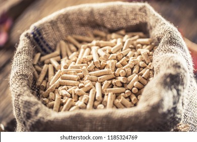 Wooden pressed pellets from biomass in old sack.