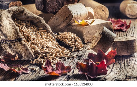 Wooden pressed pellets and briquettes from biomass with autumn leaves.
