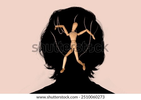 Wooden puppet doll marionette in the silhouette of a human head. Concept of emotional manipulation, world conspiracy theories., control and dictatorship