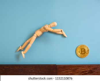 Wooden puppet jumping from the wooden floor in the air to catch the bitcoin. - Powered by Shutterstock