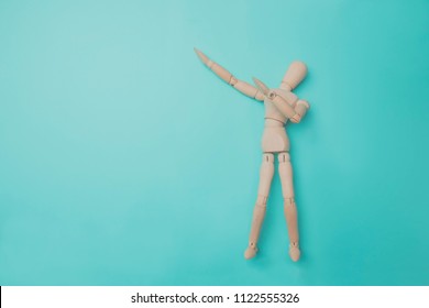 Wooden puppet points aside with its hand. Conceptual image about relax time. Minimal style. - Powered by Shutterstock