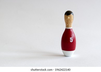 A Wooden Puppet In The Shape Of A Bowling Pin With A Number Five Shirt