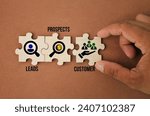 wooden puzzle with icons and the words Leads, Prospects, Customer.