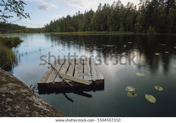 Wooden\
raft on a forest lake. Calm, suspension\
bridge.