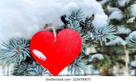 Wooden red heart on snowy tree branch in winter. Holidays happy valentines day celebration love concept.winter garden. symbol of love and family happiness. - Shutterstock ID 2256700075
