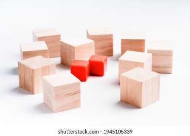 Wooden And Red Plastic Cubes On A White Background. Many Wooden Cubes But Only Two Red Ones. Concept For Choosing Priorities. Business, Choice, Decision.Not Like Everyone Else.