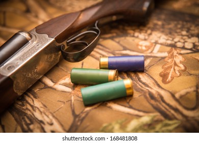 A wooden retro shotgun with shotgun shells
