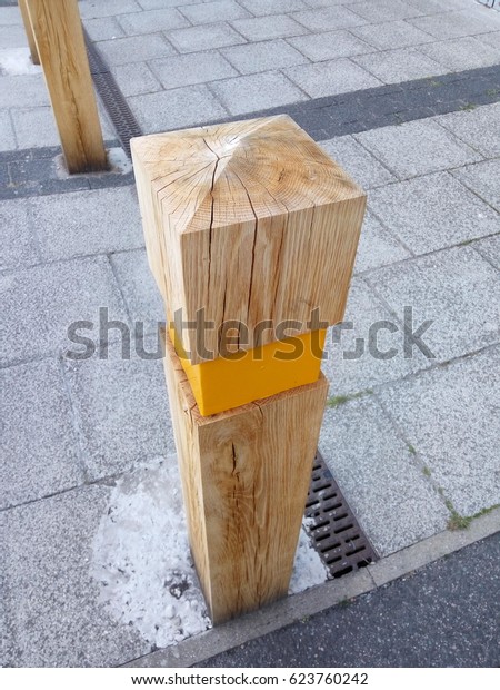 wooden road divider\
,pavement street pole with yellow road light reflector, wood grain\
details