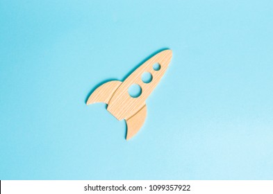 A wooden rocket on a blue background. The style is retro. The concept of space flights and achievements in high technologies. Business take off and grow. Space tourism. launching satellites - Powered by Shutterstock