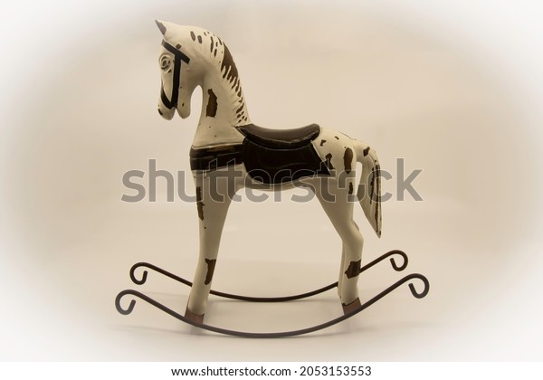 Wooden rocking\
horse toy on a light\
background