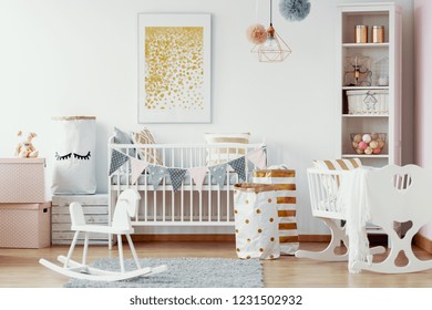 Wooden Rocking Horse, White And Gold Paper Bags And White Wooden Crib In Cozy Baby Nursery With Painting On The Wall