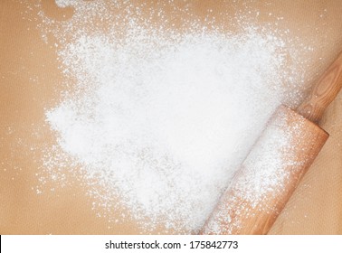 Wooden Rolling Pin With Flour On Cooking Paper. View From Above