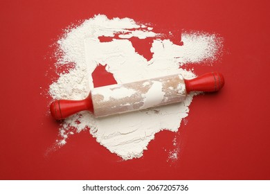 Wooden Rolling Pin With Flour On Red Background, Top View