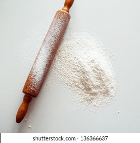 Wooden Rolling Pin With White Wheat Flour On The Table. Top View