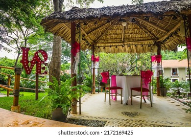 Wooden Romantic Tent With Love Motives In The Middle Of The Garden. Love Dinner Tent In The Garden. Romantic Dinner Setting In The Garden