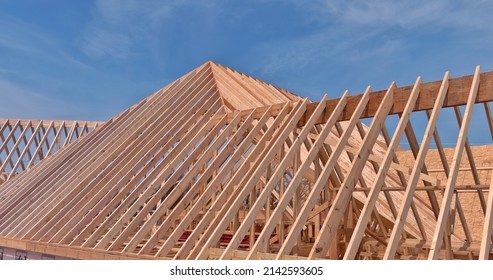 Wooden Roof Truss Framing Under Construction In New Home With A Clear Sky View