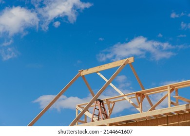 Wooden Roof Truss Framing Under Construction In New Home With A Clear Sky View