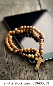 Wooden Rosary Beads With Computer Tablet On Old Wooden Table