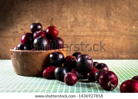 Wooden and roustic dish with fresh plums
