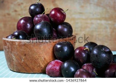 Wooden and roustic dish with fresh plums